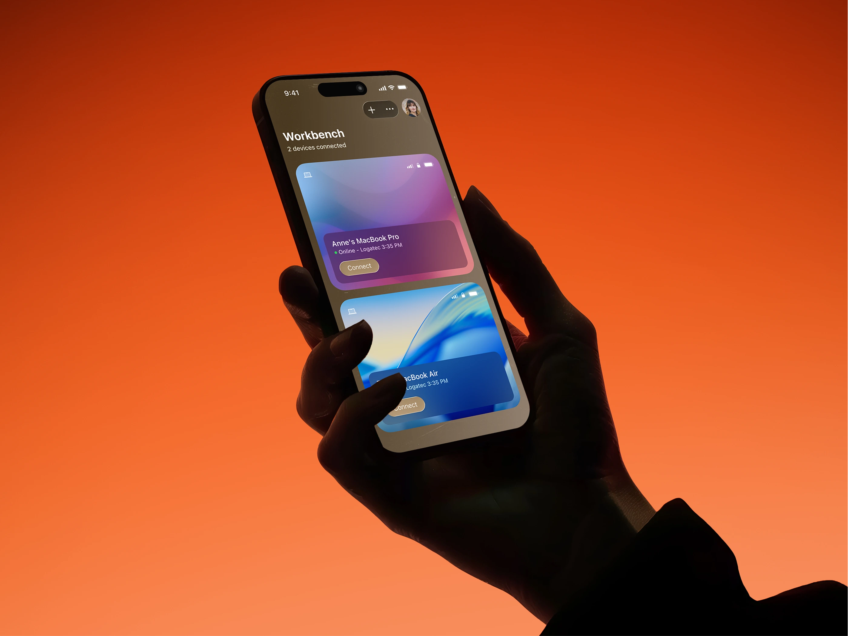 The Astropad Workbench iPhone app held in one hand, listing two connected MacBooks